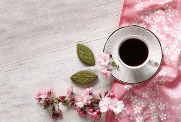 Blossom sakura branch with cup and sweets  on napkins 