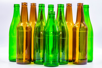 Colored empty glass bottles on white background