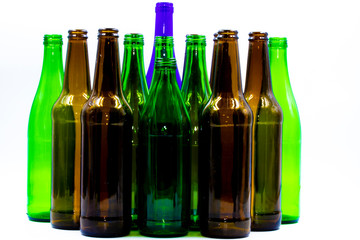 Colored empty glass bottles on white background