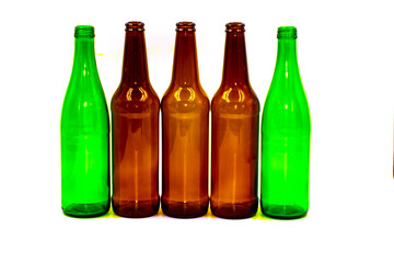 Colored empty glass bottles on white background
