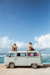 hipster boy playing guitar with girlfriend on top of retro style