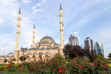 Fototapeta na wymiar Grozny, Russia: 10.07.2015. Daily life in Chechen Republic. Main mosque of the Chechen Republic - Akhmad Kadyrov Mosque (Heart of Chechnya) and and skyscrapers of Grozny-city