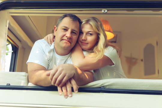 Happy couple of tourists sitting in a camper van.