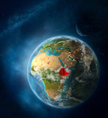 Obraz na płótnie Canvas Ethiopia from space on Earth surrounded by space with Moon and Milky Way. Detailed planet surface with city lights and clouds.