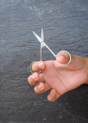 Hands are using small scissors
