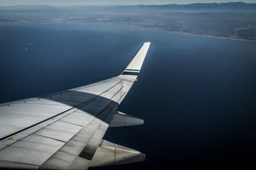 Fototapeta premium wing of an airplane flying above the clouds