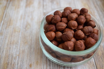 Hazelnuts in a glass jar in the background of the tree. Copy space.