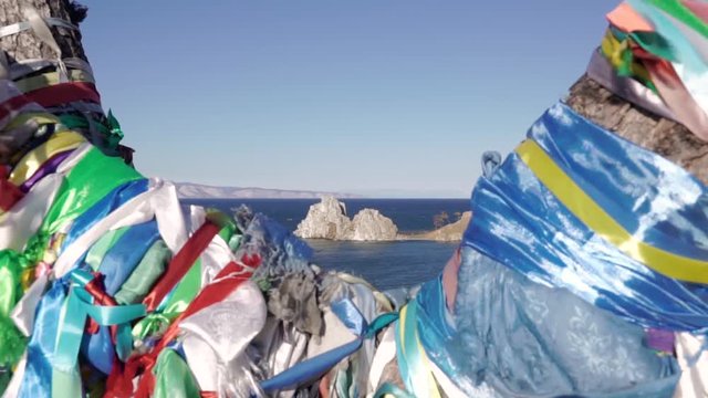 Ritual ribbons on a tree on the Olkhon island, overlooking Cape Burkhan. Lake Baikal