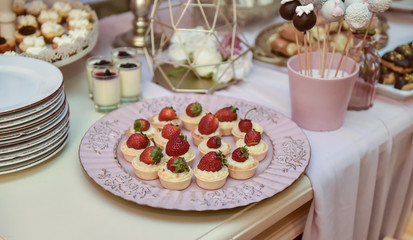 Wedding decoration with pastel colored cupcakes, meringues, muffins and macarons. Elegant and luxurious event arrangement with colorful macaroons. Wedding dessert with macaroons