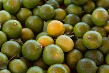 tropical south fruit food concept green lemons background texture in market place