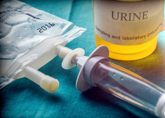 Dial flow next to a urine sample at a hospital table, conceptual image