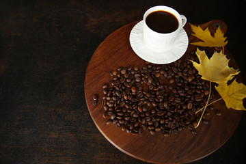 cup of coffee and beans on brown wooden background