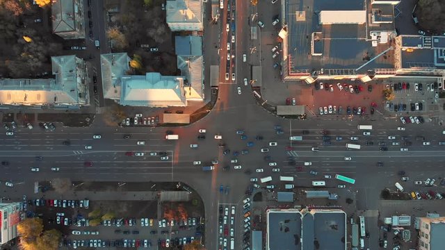 Aerial or top view from drone to European city crossroad or intersection with car traffic from above in sunset, urban transportation