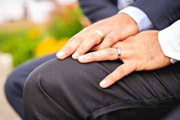 A hand with ring of gay couple in the park on their wedding day