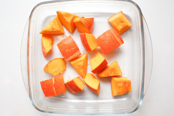 Sliced pumpkin on a plateon a  white background