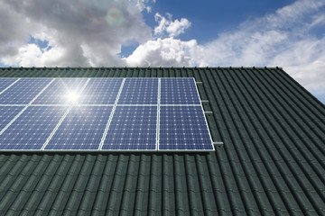 Solar panels modules on house roof with clear sky in background