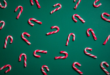 Mini candy canes on a green background