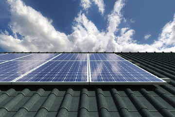 Solar panels modules on house roof with clear sky in background