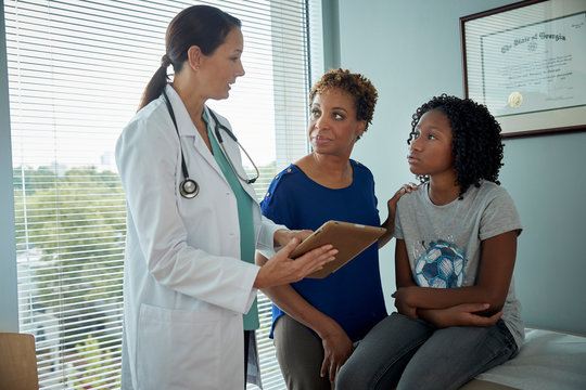 Doctor talking with mother and daughter
