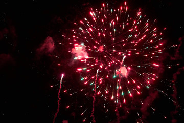 Fireworks in the night sky. Texture salute. Abstract photo of flares on a black background. Photos of lights salute in the sky. Image of salute flashes. Texture of colored lights.