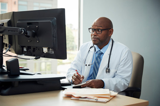 Doctor writing information from a computer