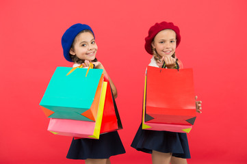 Signs you are addicted to shopping. Kids cute schoolgirls hold bunch shopping bags. Children pupils satisfied by shopping red background. Obsessed with shopping and clothing malls. Shopaholic concept