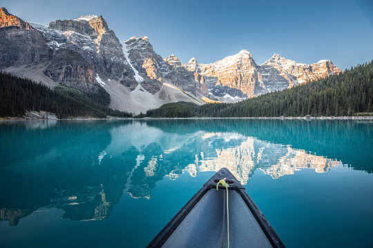 Paddling canoe on Moraine Lake during sunrise, Canadian Rockies, Canada