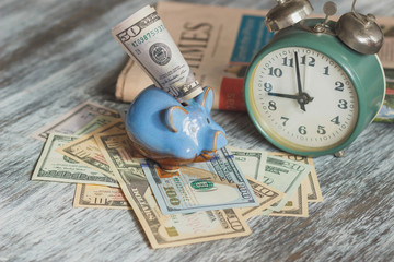 Piggy bank, alarm clock and American dollars