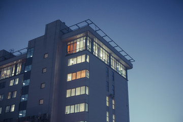 Fototapeta premium Modern office or residential building in the evening. Viewe from grownd to sky
