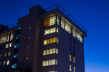 Fototapeta premium Modern office or residential building in the evening. Viewe from grownd to sky