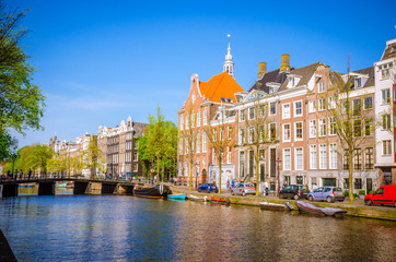Obraz premium Tradycyjne stare budynki i łodzie w Amsterdamie, Holandia. Kanały Amsterdamu.