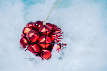 Christmas card. Red Christmas ball on a background of white feathers.