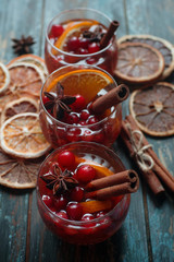 Homemade Christmas mulled red wine with spices, cinnamon and citrus fruit on rustic wooden background, traditional winter hot drink, selective focus