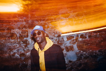 African man rapper among colorful light. Long exposure