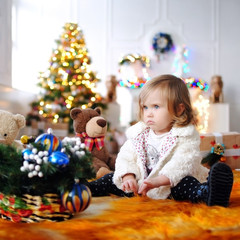 Fototapeta na wymiar Ребенок ждет чудо в Новый год. С Новым годом! Счастливого Рождества! Елка с новогодними игрушками. Девочка с подарками. 