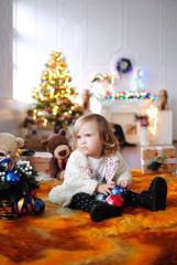 Ребенок ждет чудо в Новый год. С Новым годом! Счастливого Рождества! Елка с новогодними игрушками. Девочка с подарками. 
