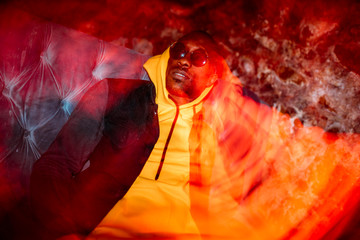 African man rapper among colorful light. Long exposure