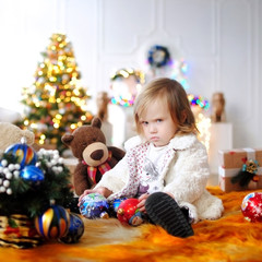 Ребенок ждет чудо в Новый год. С Новым годом! Счастливого Рождества! Елка с новогодними игрушками. Девочка с подарками. 
