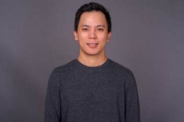 Portrait of young handsome man against gray background