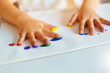  Little girl painting with hands on the paper