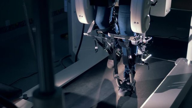 Slow motion footage of legs of a physically challenged man walking in a simulator