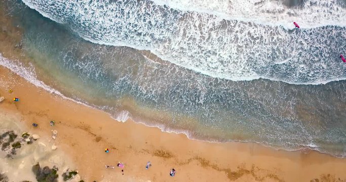 Scenic aerial drone view of yellow sandy beach and turquoise mediterranean sea with big waves and foam. Golden beach, Malta. View from above