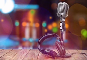 Retro style microphone and headphones on  background