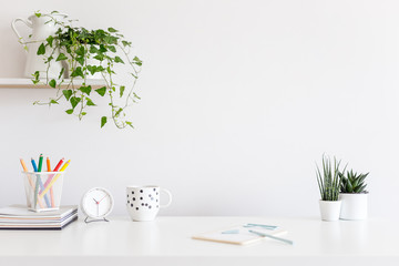 Coffee and alarm clock on white office desk of designer. © mallmo
