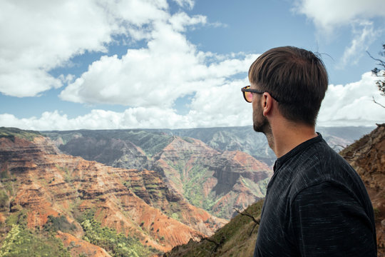 Young man with sumglasses staring at Waimea Canyoyn