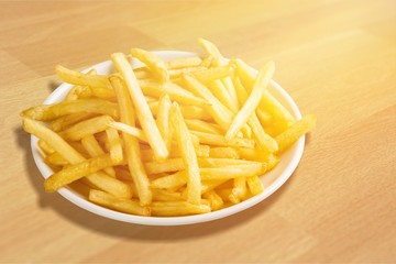 Plate of french fries on wooden table