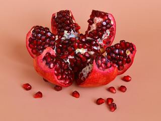 Ready to eat red ripe juicy pomegranate fruit with seeds, healthy eating concept on an orange...