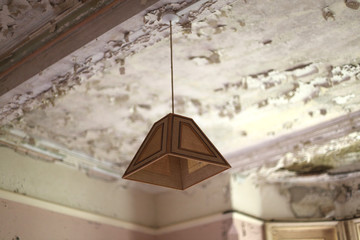 old fashioned light shade on decaying ceiling