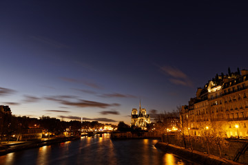 Notre dame de Paris by night and the seine river in the city of Paris in france