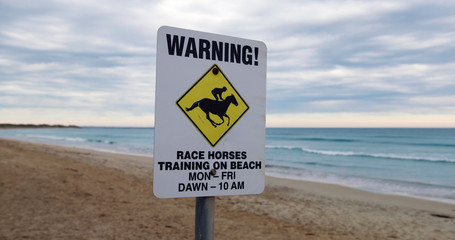 Low shot of race horses sign on Golfies Beach, Australia.
